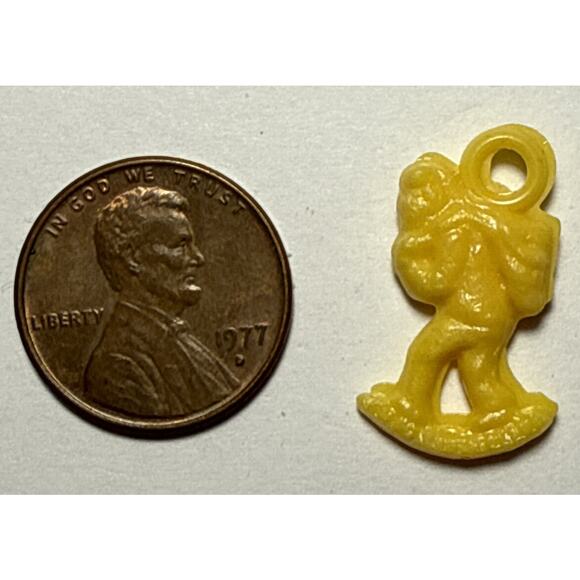 Vintage Cracker Jack Yellow Person Carrying Bag Celluloid Charm 1G - Picture 1 of 2